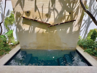 This installation from Vision Pools provides access from both sides along with tiered seating, which allows users to choose a comfortable depth in the icy water. The charming natural water feature above offers both visual and audio enhancement to the cold plunge experience.