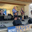 Senior rock band performing on outdoor stage with musical equipment