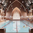 Indoor swimming pool with lane dividers in a historic brick cathedral-like building