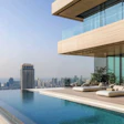 Infinity pool overlooking urban skyline from modern glass-walled luxury penthouse