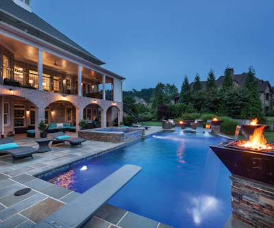 Fire bowls create nighttime ambiance. The dramatic flames are well balanced by the home's exterior lighting.