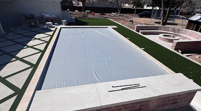 While the deep end typically houses the cover box, this project reverses the standard layout, relocating the automatic cover to accommodate a slide and water features without sacrificing access to the cover mechanism.