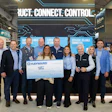 Hayward corporate team posing with large branded check at industry conference