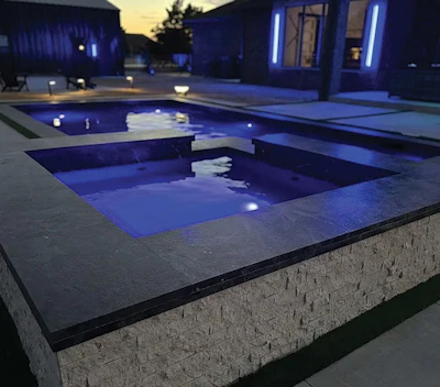 Mid-size cocktail pool with double-stacked marble coping and a spillover spa. This is the kind of project where material selection and proportion make all the difference.