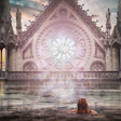 Woman wading in water before a glowing Gothic cathedral with ornate rose window and twin spires at sunset.