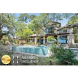 Luxury modern home with turquoise pool surrounded by mature trees and manicured landscaping, featuring 2026 Awards of Excellence gold badge