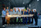 Group of business professionals at ribbon-cutting ceremony for King facility opening