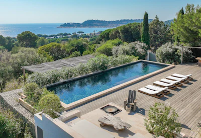 Luxury Mediterranean villa with infinity pool overlooking coastal bay and mountains