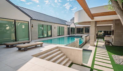 Modern luxury home with resort-style swimming pool, contemporary architecture, and manicured landscaping