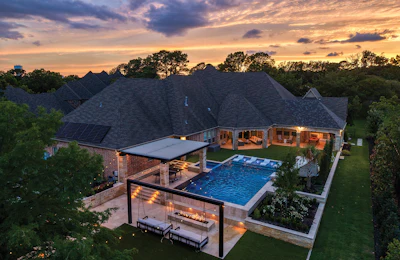 Luxury home with pool and covered patio at golden hour sunset