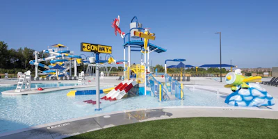 Colorful water park with blue and yellow slides, wave pool, and recreational attractions under clear sky