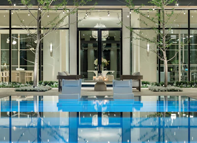 Modern luxury home with infinity pool, contemporary glass facade, and minimalist outdoor seating area