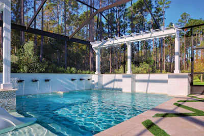 Modern residential pool with white pergola, screened enclosure, and surrounding pine trees