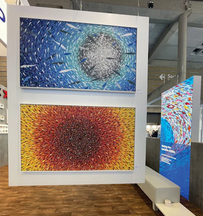 Two large abstract artworks with radiating concentric patterns displayed on a white panel in a gallery space