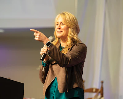 Woman speaking at podium with microphone during presentation event