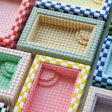 Colorful checkered fabric swatches arranged in compartments showing various color combinations and patterns
