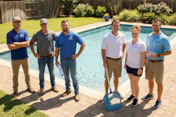 Six team members in casual work attire standing together by a residential swimming pool on a sunny day