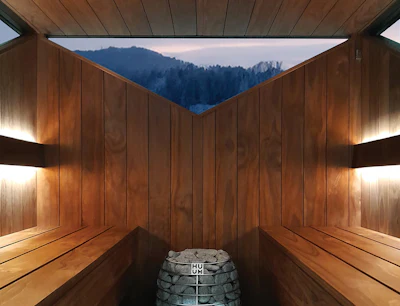 Modern wooden sauna interior with mountain landscape view through open ceiling