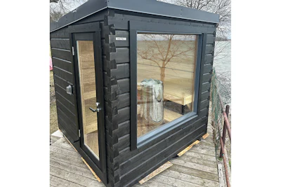 Modern black garden shed with large windows and wooden door on wooden deck