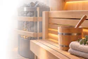 Luxury spa interior with wooden sauna, heated rocks, ambient lighting, rolled towels, and decorative plants