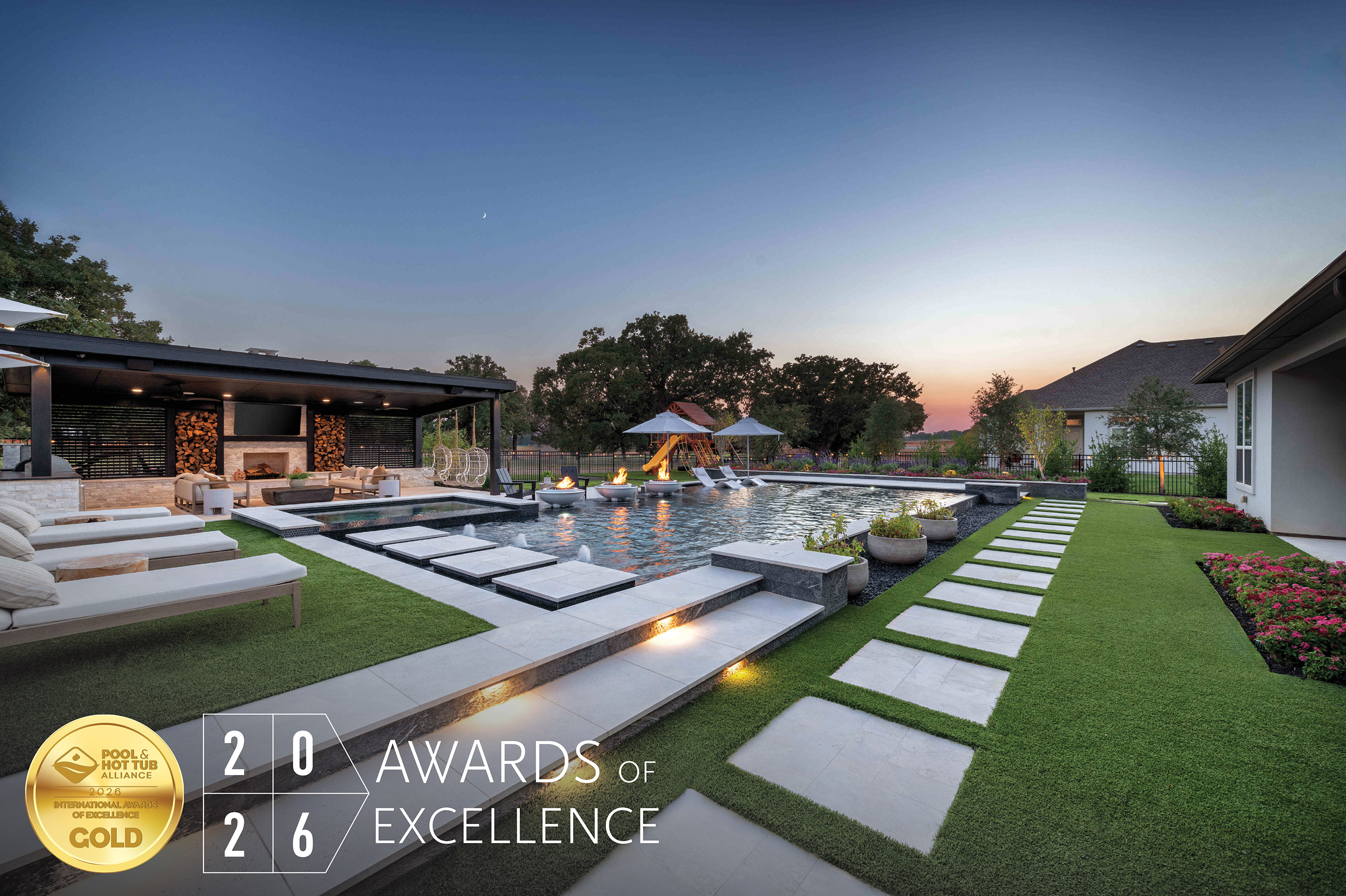 Luxury modern home with illuminated pool and manicured lawn at dusk, featuring HIA 2026 Gold Award of Excellence badge