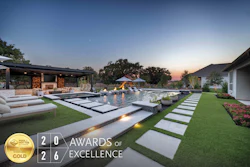 Luxury modern home with illuminated pool and manicured lawn at dusk, featuring HIA 2026 Gold Award of Excellence badge