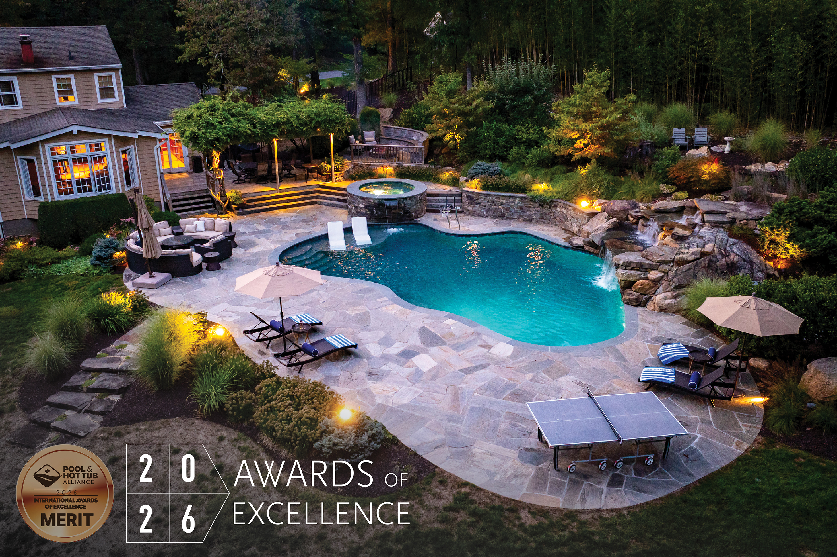 Luxury backyard pool with stone patio, ambient lighting, and 2026 Awards of Excellence merit badge