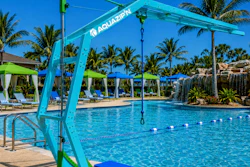 Turquoise pool hoist with Aquazion branding at a resort pool with palm trees and lounging areas