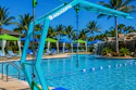 Turquoise pool hoist with Aquazion branding at a resort pool with palm trees and lounging areas