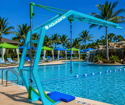 Turquoise pool hoist with Aquazion branding at a resort pool with palm trees and lounging areas